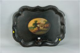 A large Victorian papier mache tray, black ground with faded gilt decorated swags, a central oval