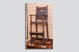 A 19th Century oak child's highchair with carved panelled back, shaped arms on turned bobbin