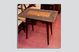An Edwardian carved oak side table, a plain centre rectangular pattern surrounded by a leaf and