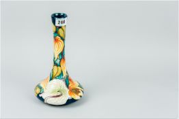 A Moorcroft squat form narrow necked vase, deep turquoise ground, the body extensively decorated