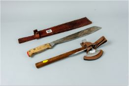 A steel bladed wooden handled machete marked 'Martindale, Birmingham' in a leather sheath, the