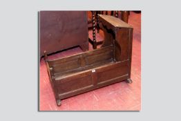 A late 18th/early 19th Century oak cradle, chamfered panelled with a slope shaped sided canopy