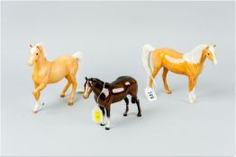 Three various Beswick pottery horses, two in palomino colours and one chestnut (damage to one leg)