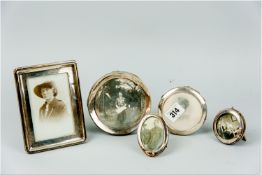 A parcel of five silver picture frames being two miniature, two circular and one oblong