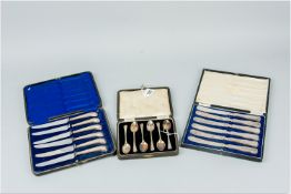Two cased sets of six silver handled tea knives and a cased set of six electroplated coffee spoons