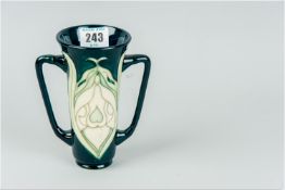 A Moorcroft slender two handled flared neck vase having a deep blue green interior and body with