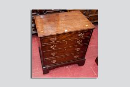 A Georgian mahogany chest of drawers of small proportions, four various sized drawers with cock bead