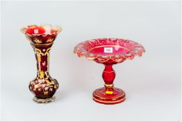 A large red glass overlaid pedestal comport, the border with plain star and circular 'cut-outs'