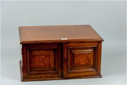 An early 20th Century collector's cabinet, oak with a simple moulded top leading down to two opening