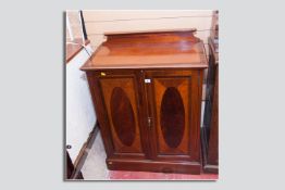 A very nice quality boxwood inlaid and crossbanded mahogany two door cabinet with oval mahogany