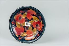 A Moorcroft blue ground plate with tube lined 'Pomegranate' pattern, 8.5 ins (21.5 cms) diam, (glaze