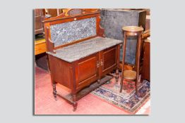 An Edwardian mahogany washstand with a black marble top and a black and white veined mahogany