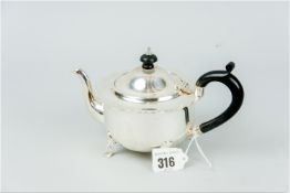 A plain circular silver bachelor teapot on four web supports with composition handle and knop, 8.5