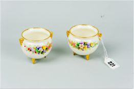 A pair of Worcester cauldron shaped pots having hand painted floral swags either side, gilt