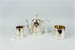 A three piece electroplated tea service, each piece of circular form with incised leaf decoration,