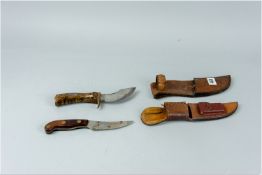 Two wood and brass handled hunting knives in leather sheaths, one marked by 'W F Moran'