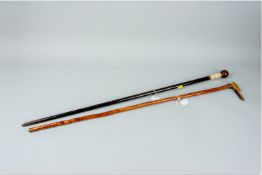 A walking cane with a carved horn dog's head handle and another cane with a ball shaped handle above