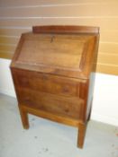 A light oak Brynmawr Furniture sloped-bureau with panelled fall-front revealing an arrangement of
