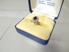 An 18ct white gold sapphire and diamond floral ring, 5gms