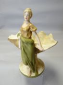 A Royal Dux jardiniere in the form of a maiden leaning upon a giant clam on a naturalistic base
