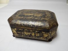 A Chinese lacquer ware octagonal writing box on claw fore-feet, hinged lid above single drawer,