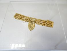 A 9ct yellow gold gate bracelet with heart-shaped pad-lock, 15.08gms