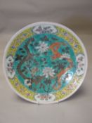 A nineteenth century polychrome Chinese charger decorated with dragons in branches, 14 ins