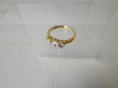 A three-stone diamond ring of believed 18ct yellow gold (hallmarks are worn), visual estimate of