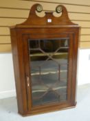 A neat nineteenth century mahogany hanging corner cabinet, the single astragal glazed door enclosing