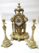 A Rococo style French yellow metal mantle clock with cherubic figure holding aloft the circular dial