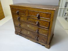 A stained pine apprentice chest of three long and two short drawers with turned knobs having