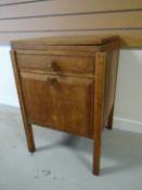 A light oak Brynmawr Furniture night cabinet / sewing table with swivel-fold top above a single