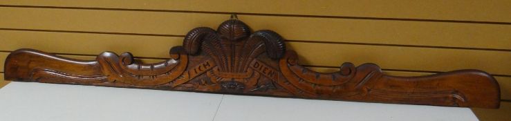 A mahogany furniture cornice carved with the Prince of Wales Feathers and 'ICH DIEN', 77 ins long (
