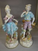 A pair of Capodimonte circular based peasant figures in pastel glazes, 29 ins high (74 cms)