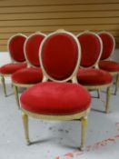 A set of six French-style salon chairs having oval backs and seats upholstered in buttoned red