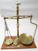 A set of antique brass pharmaceutical scales on mahogany platform base and with brass disc weights