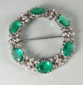 A vintage white metal circular floral costume brooch
