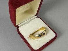 An exceptionally large 22ct yellow gold ring set with three blue sapphires, 10.68 gms