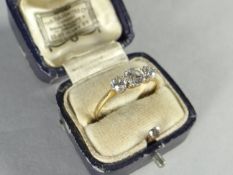A 9ct yellow gold three-stone diamond ring, the larger centre stone having an approximate visual