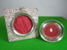 A silver easel portrait frame for circular display and with square embossed frame; together with a