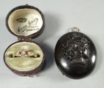 A bog-oak oval locket with raised portrait to the front and hinging to reveal two inscribed scenes