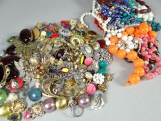 A parcel of mixed jewellery and a bag of costume beads