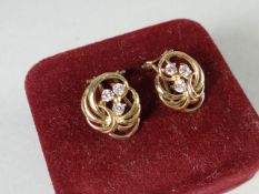 A pair of 18ct yellow gold abstract earrings with three small diamonds to each