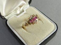 An antique 15ct yellow ring set with a row of rubies, tiny diamonds, and having split shoulders, 2.
