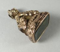 An unmarked yellow metal and green agate seal pendant decorated in relief with greyhounds in chase