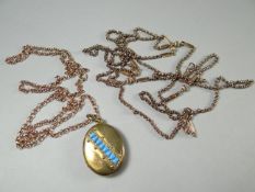 A yellow metal necklace attached to an unmarked yellow gold and turqouise-set oval locket;