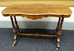 A burr walnut occasional table having a shaped bevelled top above a shaped frieze on turned and