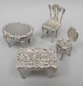 Four silver doll's house furniture items with rococo-style embossed decoration