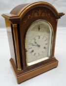 A Wurttemberg inlaid mahogany arched chiming mantel clock of architectural form with silvered dial