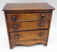 A late-nineteenth century mahogany small apprentice chest of three graduated drawers, with shaped